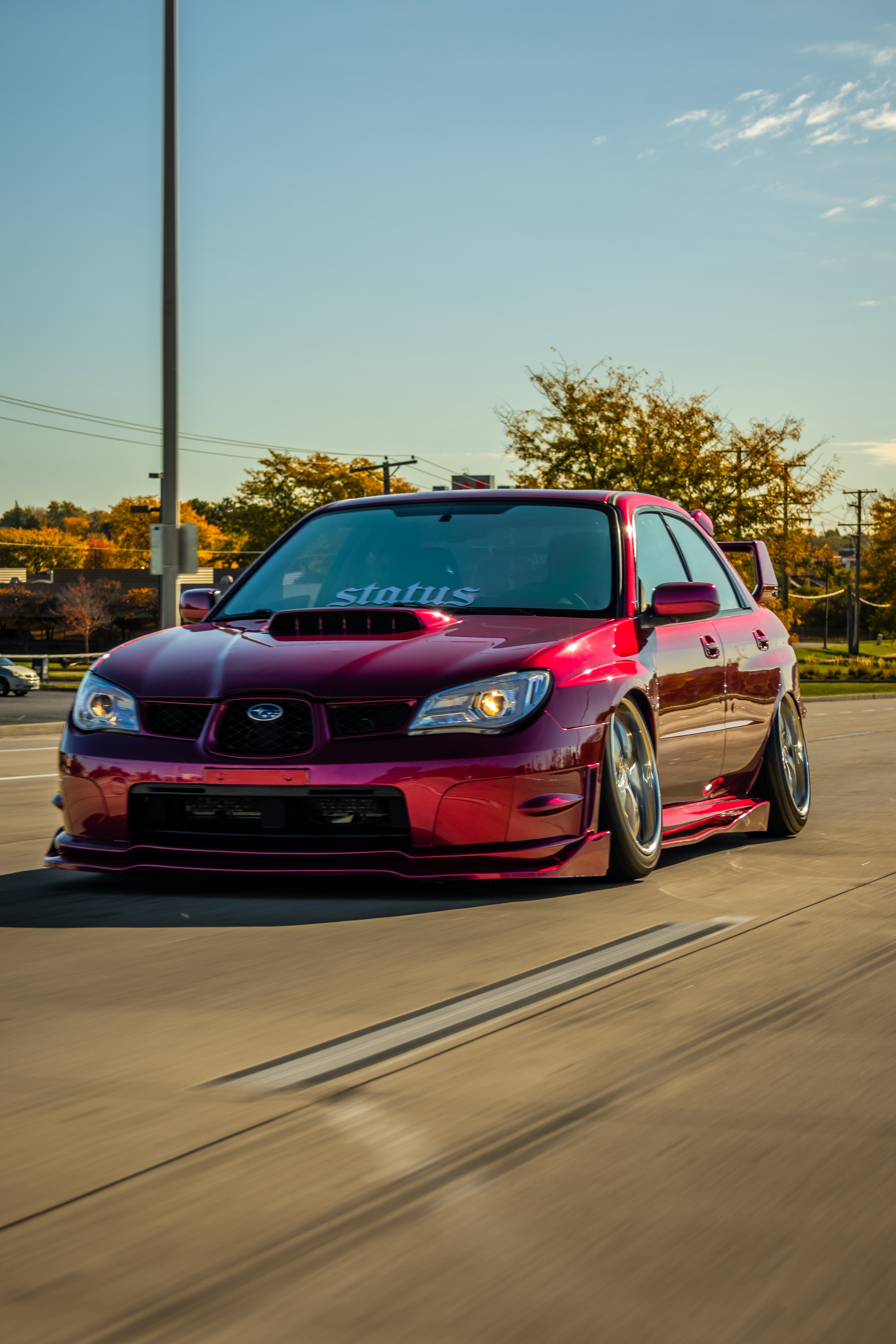 Custom magenta Subaru WRX STI rolling shot after detailing