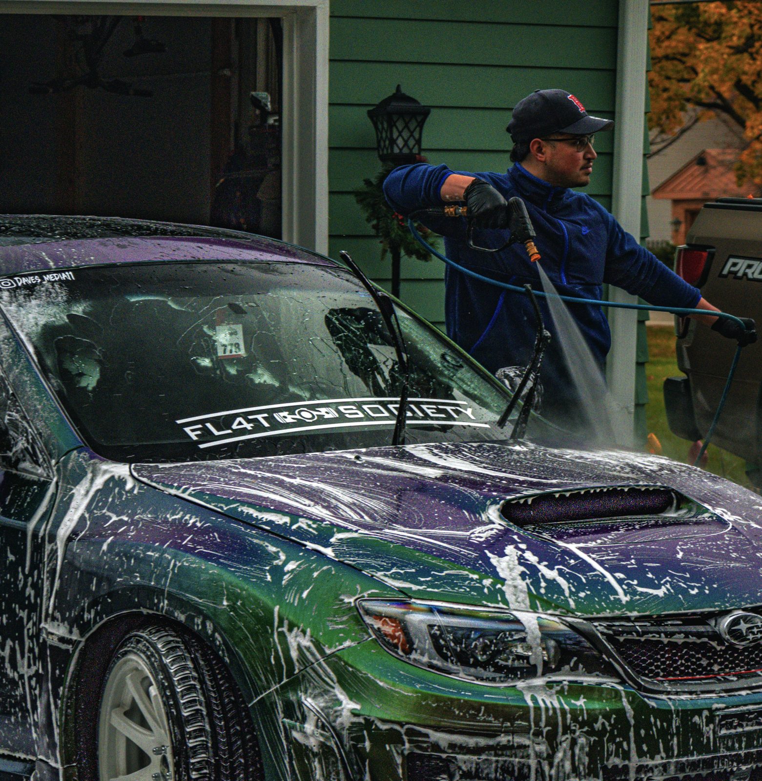 David washing a chameleon-wrapped Subaru STI — a Styluxe detail in progress